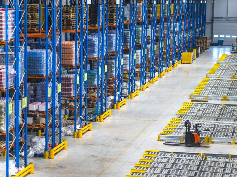 Distribution warehouse building interior and large storage area with goods on the shelf.